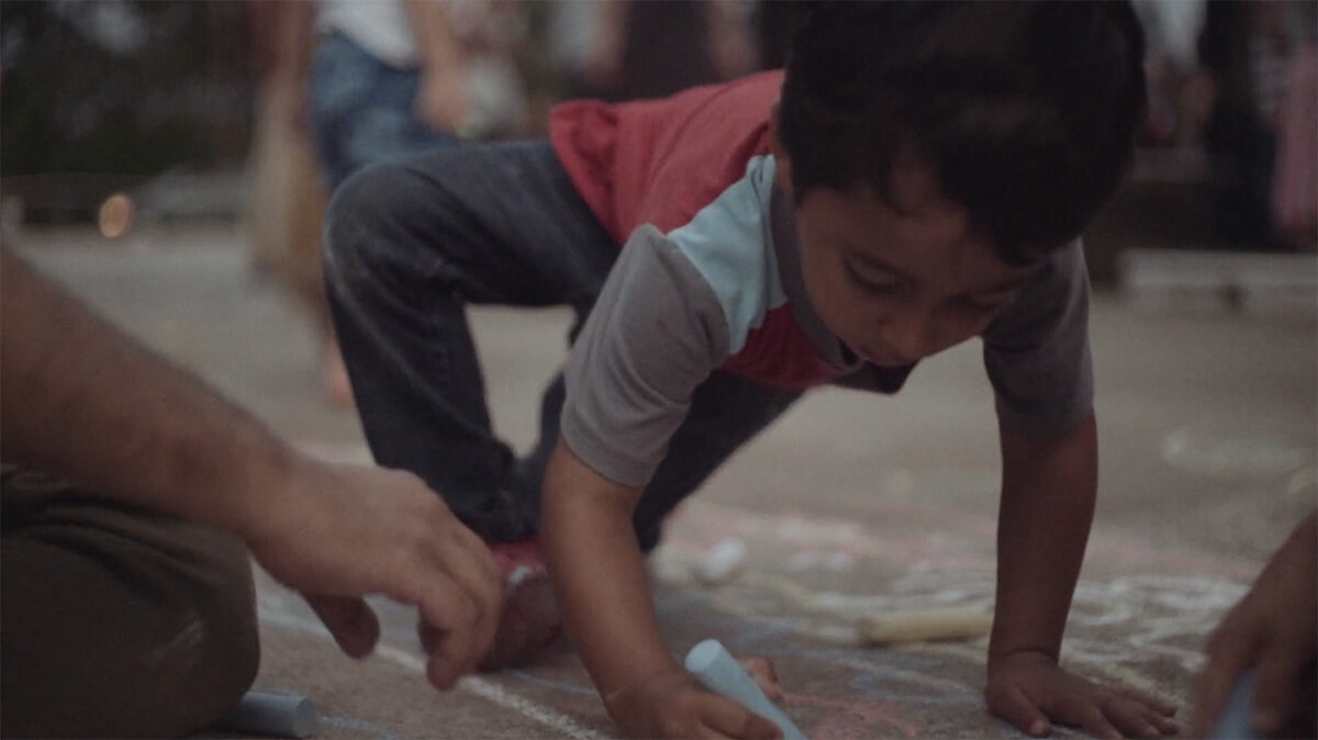 A young boy writing in chalk